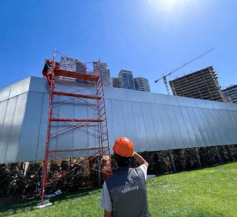 Chantier palissade Cap Towers Tanger - Équipe AdKey Signs en gilet et casque sur site